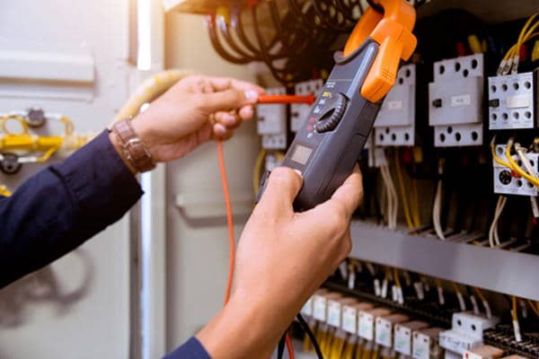 domestic electrician measuring the electrical safety of control panel